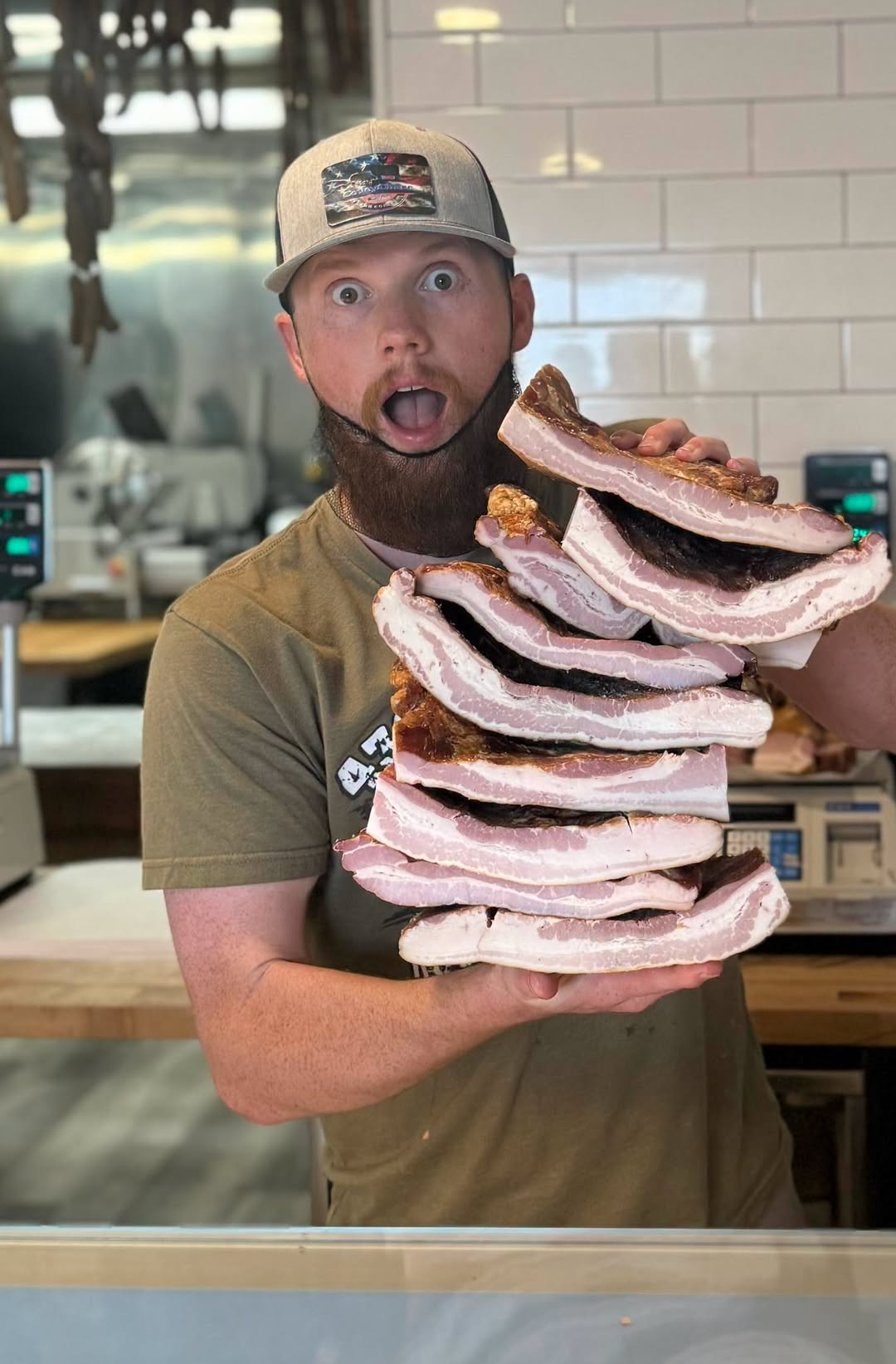 A member of the Harv’s team holding a stack of bacon